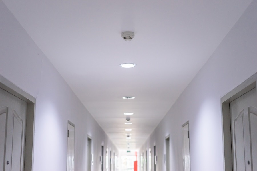 Fire compliance requires smoke detector placement throughout a commercial building.